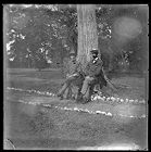 Two men named W. N. Old and N. Penick resting against a tree on the grounds of Bayside Plantation, Pasquotank County, North Carolina